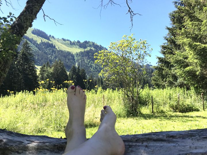 Blick in eine schöne Landschaft, im Vordergrund Füsse
